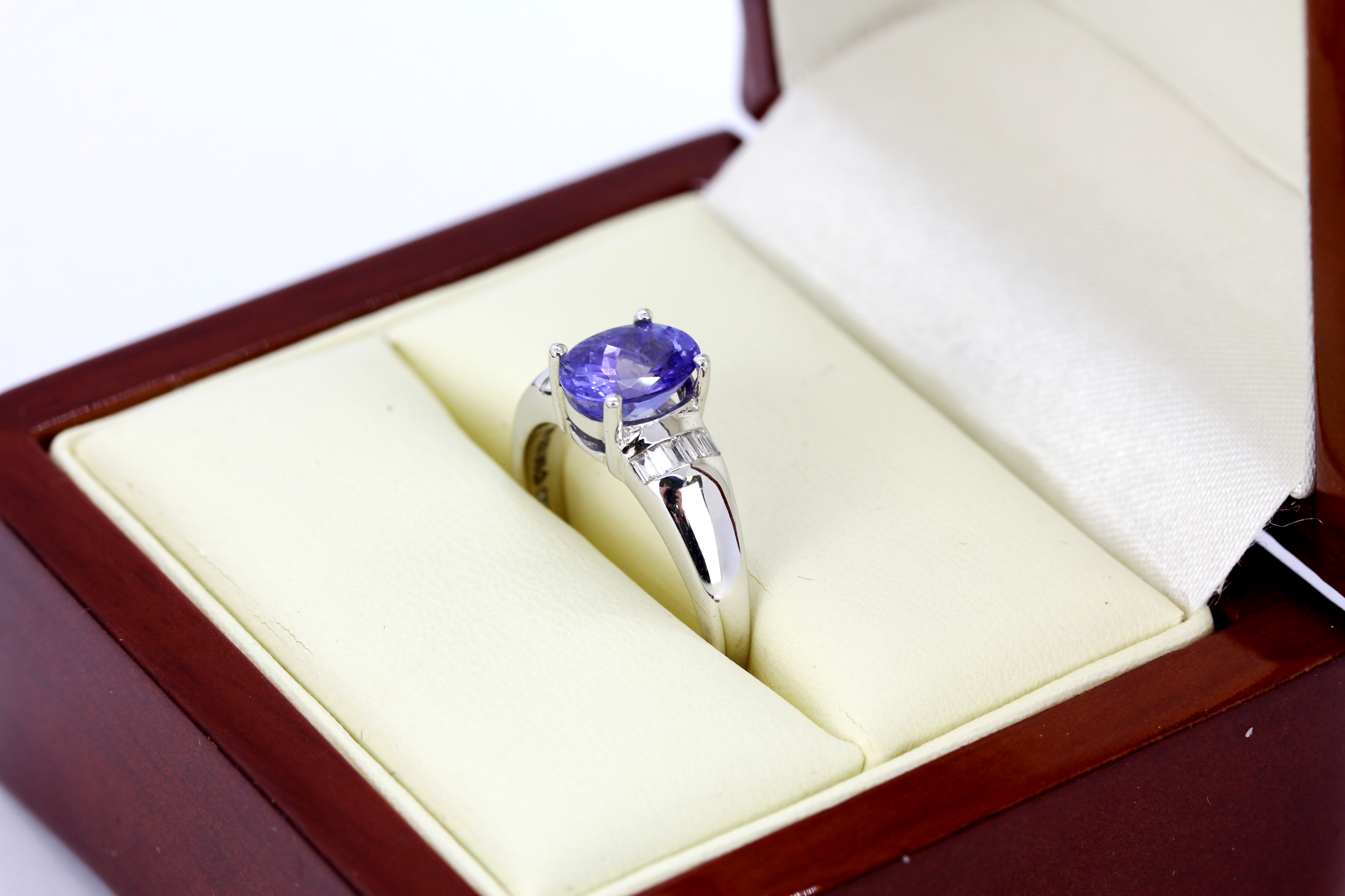An 18ct white gold ring set with an oval cut tanzanite and diamond set shoulders, (M.5). - Image 5 of 5