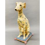 A large painted plaster figure of a dog sitting on a cushion, H. 54cm, slightly A/F to back tassle.