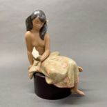 A large Lladro porcelain figure of a Polynesian girl with a bird, H. 33cm