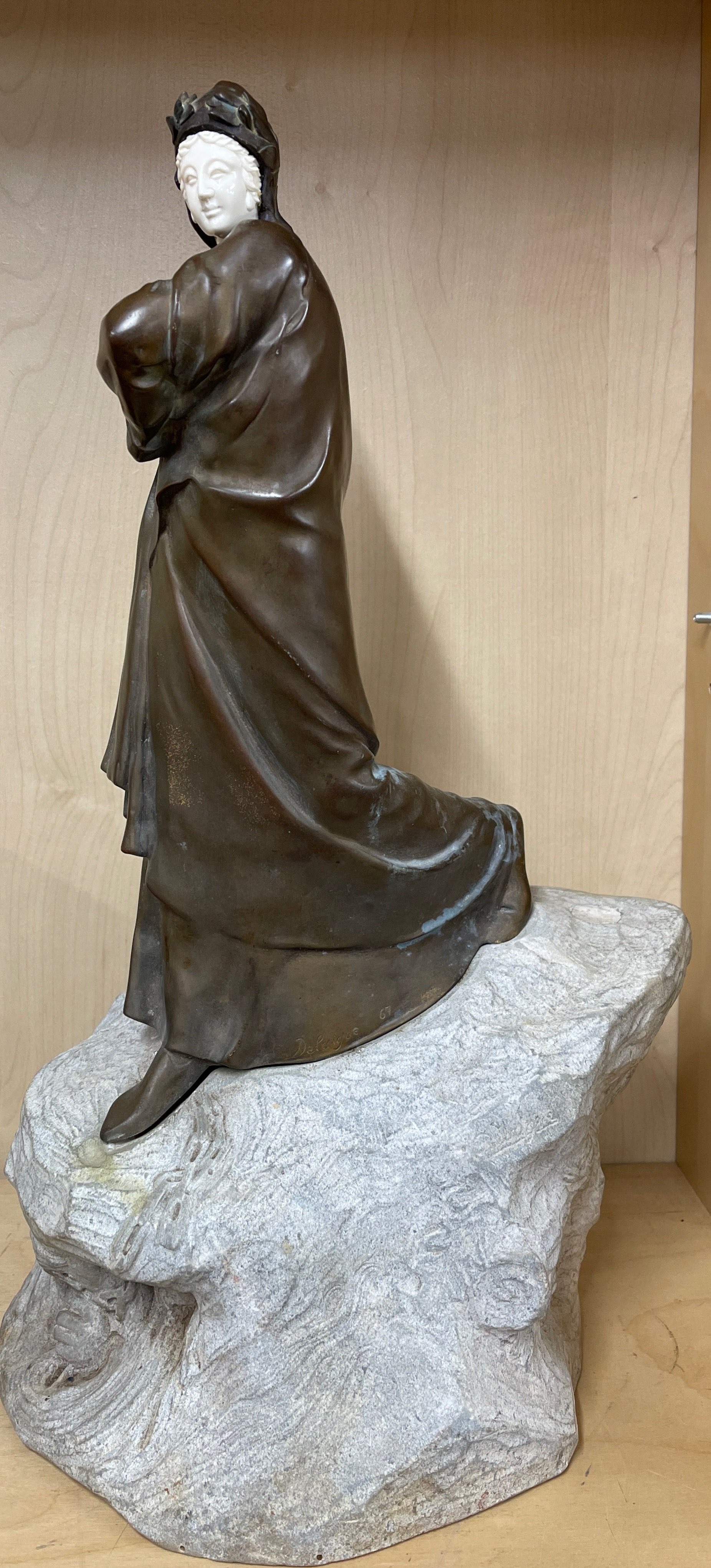 A superb early 20th century bronze figure of a woman with a coat, mounted on a carved stone base - Image 2 of 4