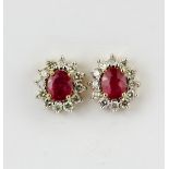 A air of 9ct yellow gold (stamped 9k) cluster earrings set with oval cut rubies surrounded by