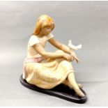 A large Lladro figure of a girl with a dog on a base, H. 30cm.