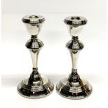 A pair of hallmarked silver candlesticks, H. 18cm. (weighted).
