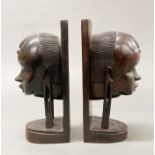 A pair of carved African figured ebony bust book ends, H. 25cm.