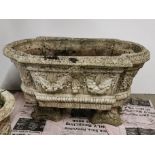 A large concrete garden planter with relief decoration on two separate feet/ bases, 80 x 42 x 47cm.