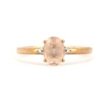 A 9ct rose gold ring set with an oval cut morganite and diamond set shoulders, (T.5).