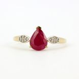 A 9ct yellow gold ring set with a pear cut ruby and diamond set shoulders, (T.5).