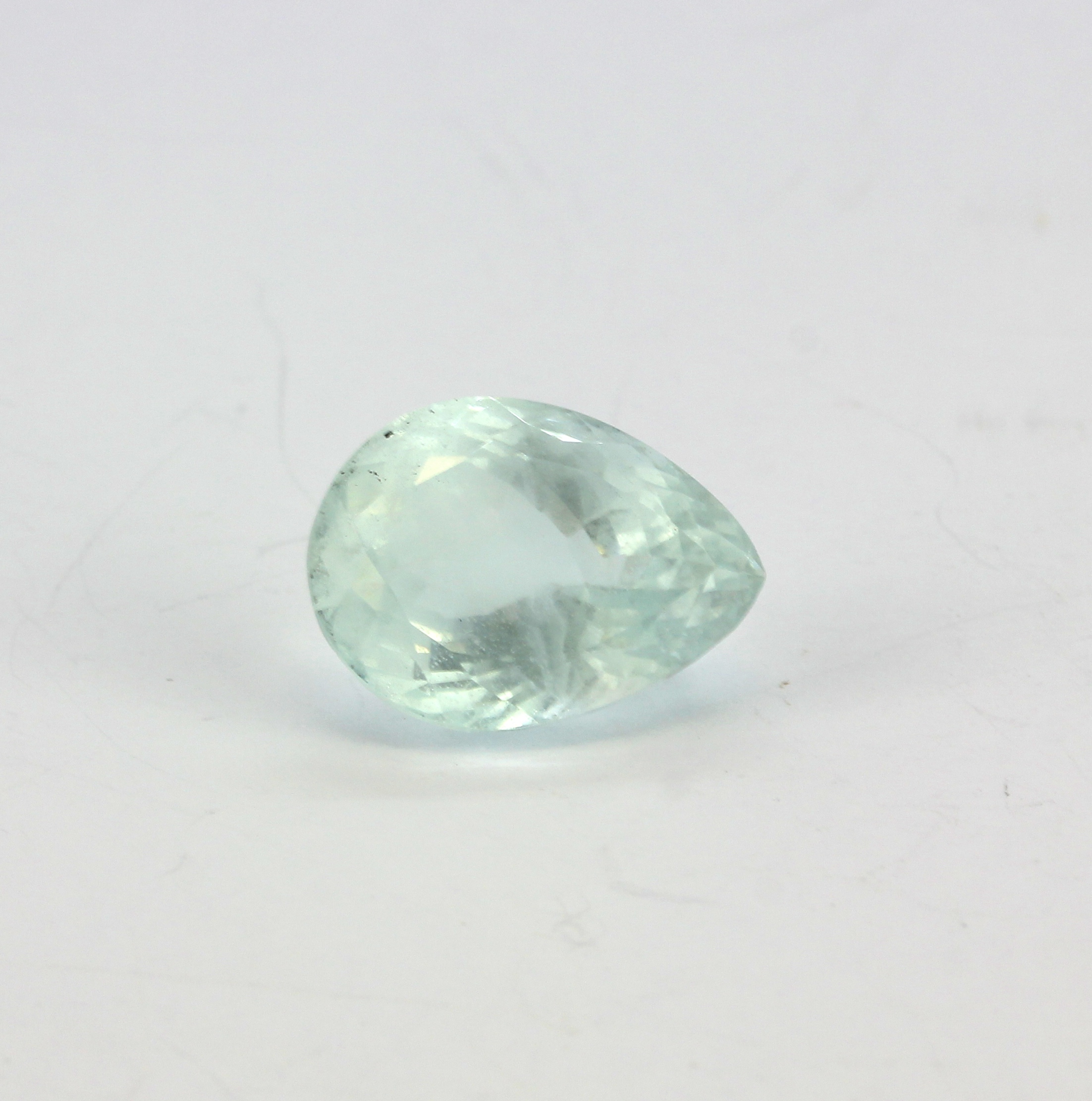 An unmounted pear cut aquamarine with a certificate, 1.9x1.4cm.