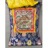 A Tibetan silk mounted hand painted thangka, overall size 50 x 68cm.