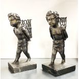 A pair of painted bronze figures of boys carrying baskets, H. 18cm.