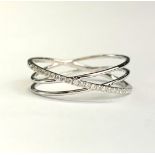 An 18ct white gold (tested) crossover ring set with brilliant cut diamonds, (N).