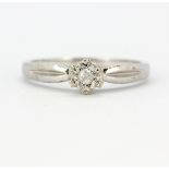 A 9ct white gold (stamped 375) diamond set solitaire ring, (M.5).