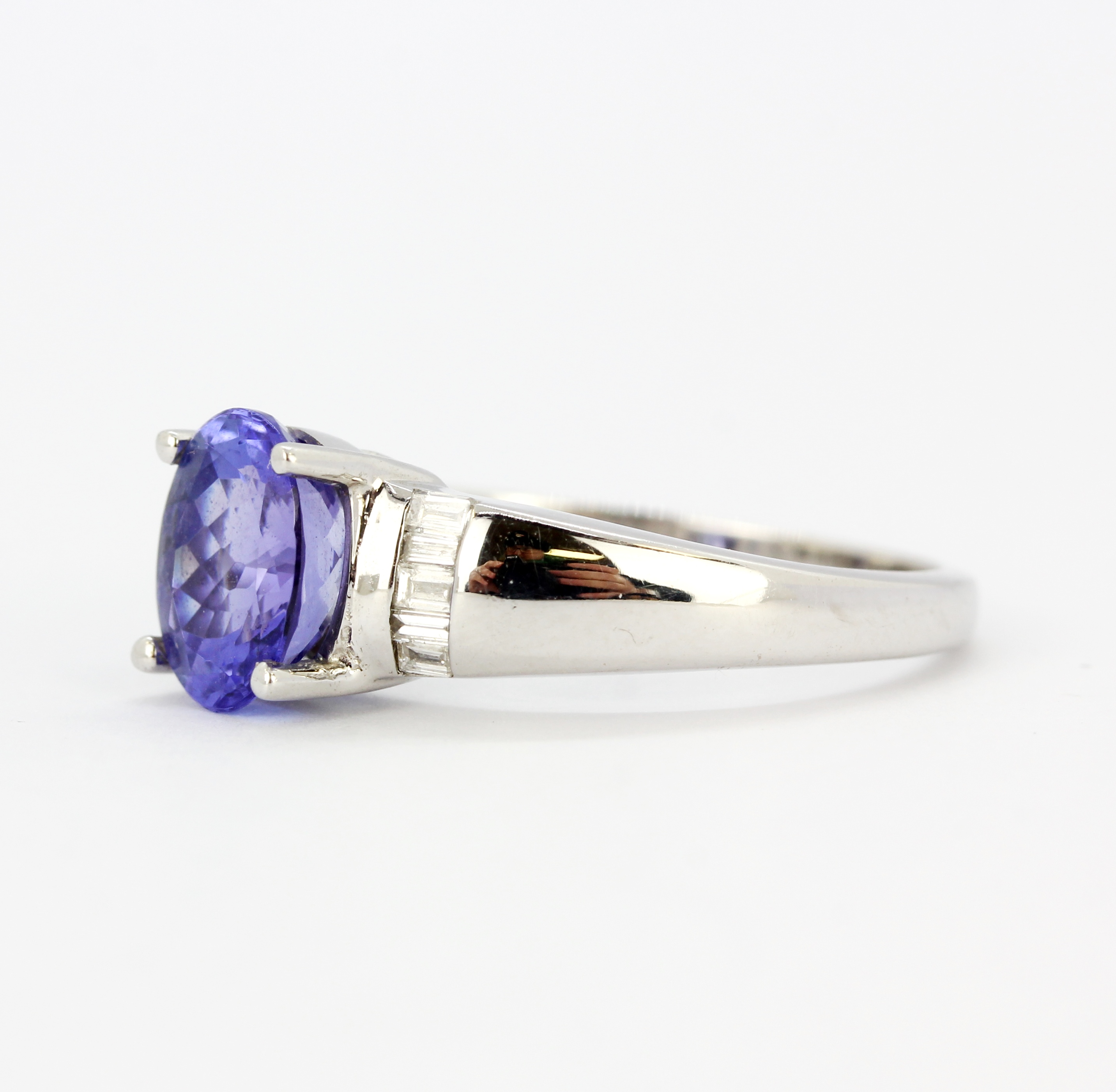 An 18ct white gold ring set with an oval cut tanzanite and diamond set shoulders, (M.5). - Image 2 of 5