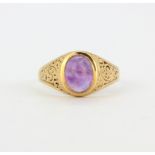A 9ct yellow gold (tested) ring set with cabochon cut amethysts, (T).