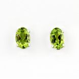 A pair of 18ct white gold stud earrings set with peridots, L. 0.5cm.