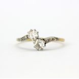 An antique 18ct yellow gold cross over ring set with old cut diamonds and diamond set shoulders,