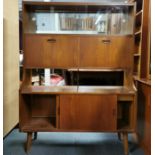 A teak mirror backed display cabinet with teak and glass sliding doors, access to the bottom