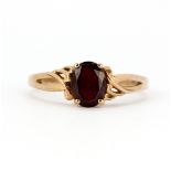 A 9ct rose gold (stamped 375) ring set with an oval cut garnet, (T.5).