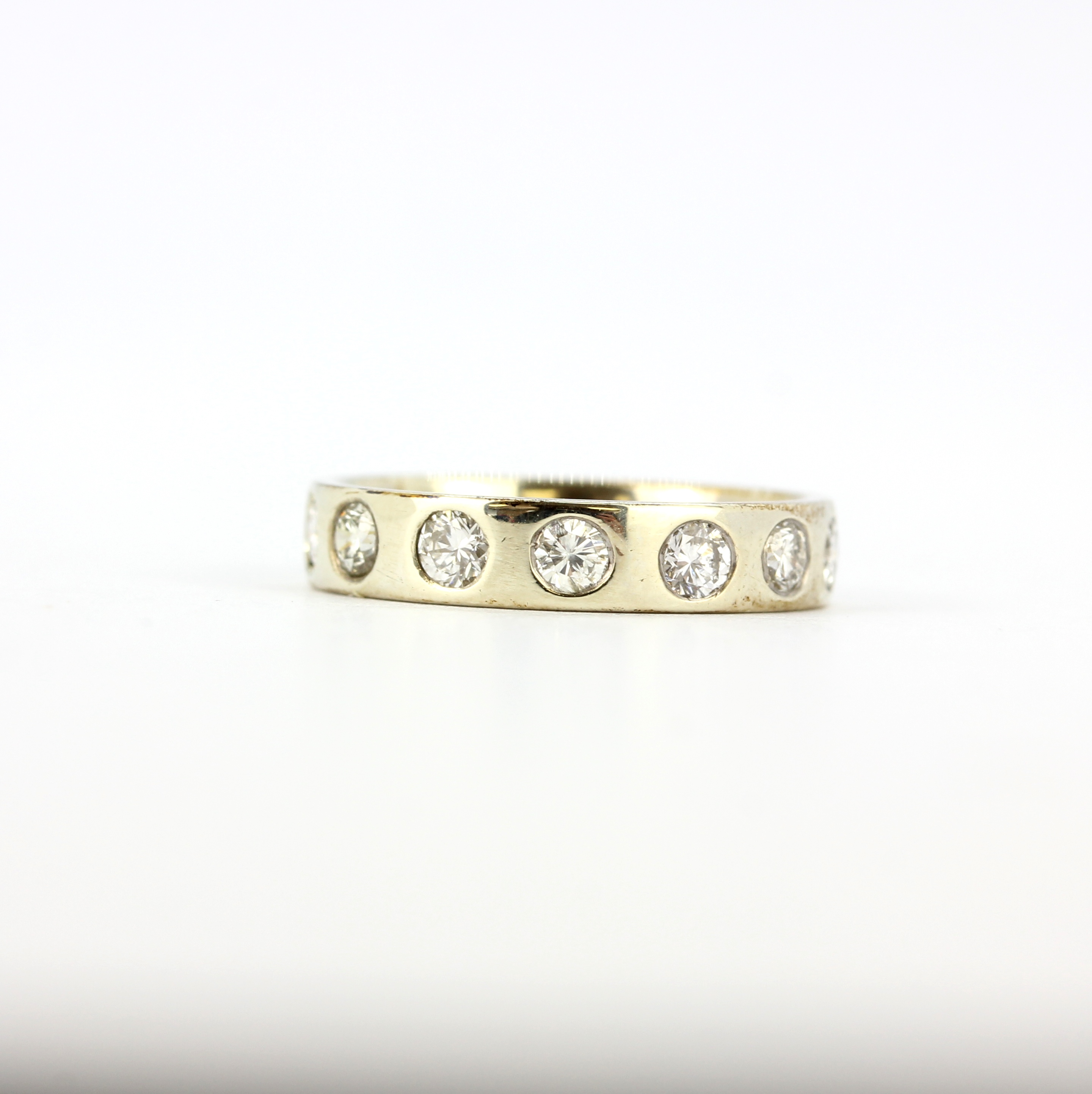 A white metal (tested 14ct gold) full eternity ring set with brlliant cut diamonds, approx. 1ct