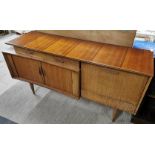 A 1970's teak sideboard with sliding door and a drop down cabinet with glass shelf, 145 x 79 x