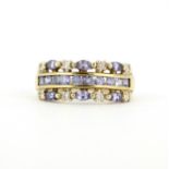 A hallmarked 9ct yellow gold ring set with marquise and round cut tanzanites and diamonds, (P.5).