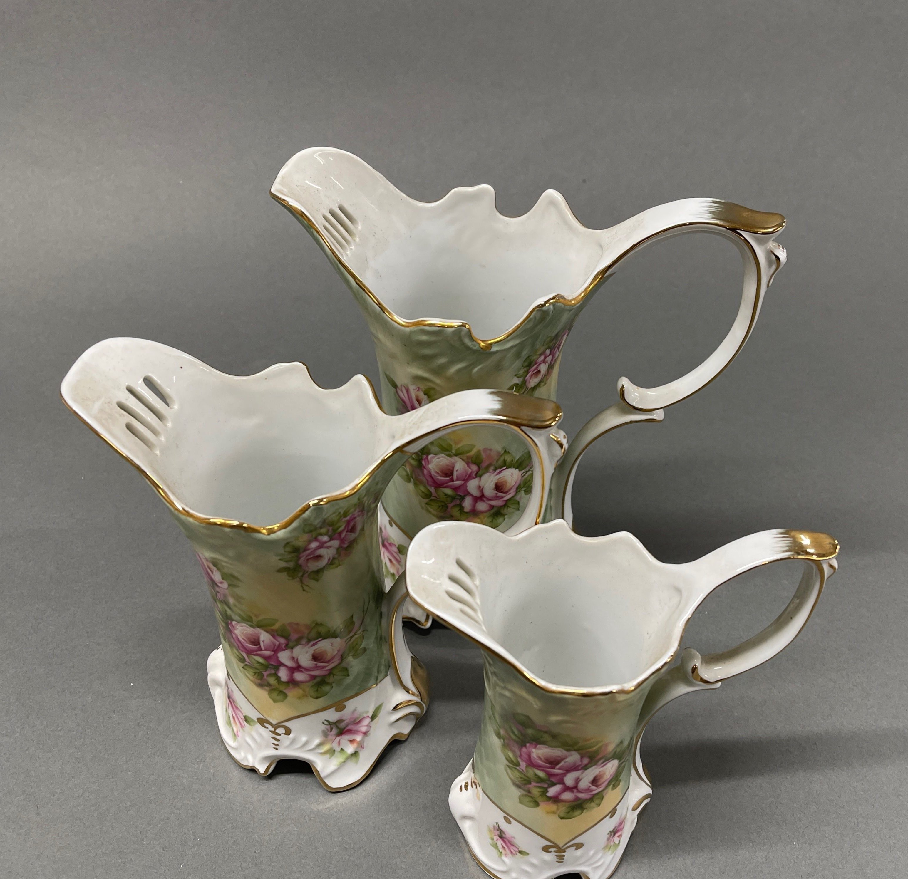 A very pretty graduated set of three Continental hand painted porcelain jugs, tallest H. 22cm. - Image 2 of 2