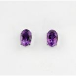 A pair of 18ct white gold (stamped 750) stud earrings set with oval cut amethysts, L. 0.6cm.