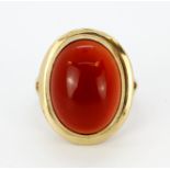 A 9ct yellow gold ring set with a large cabochon cut cornelian, (L.5).