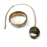 An engraved hallmarked silver bangle and locket with chain.