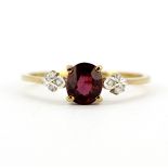 A 9ct yellow gold ring set with a rubellite garnet and diamonds, (T.5).