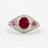 An 18ct white gold (stamped 750) ring set with a round and pear cut rubies and diamonds, (one pear