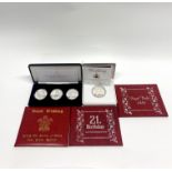 Two sets of silver commemorative coins and three 23ct yellow gold commemorative stamps.
