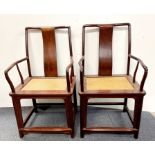 A pair of Chinese hardwood scholar's chairs with rattan inset seats, H. 102cm. Slightly A/F.