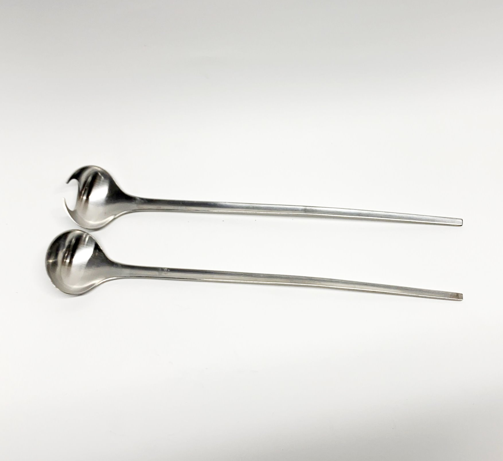 A pair of Georg Jensen stainless steel Tuja salad servers.