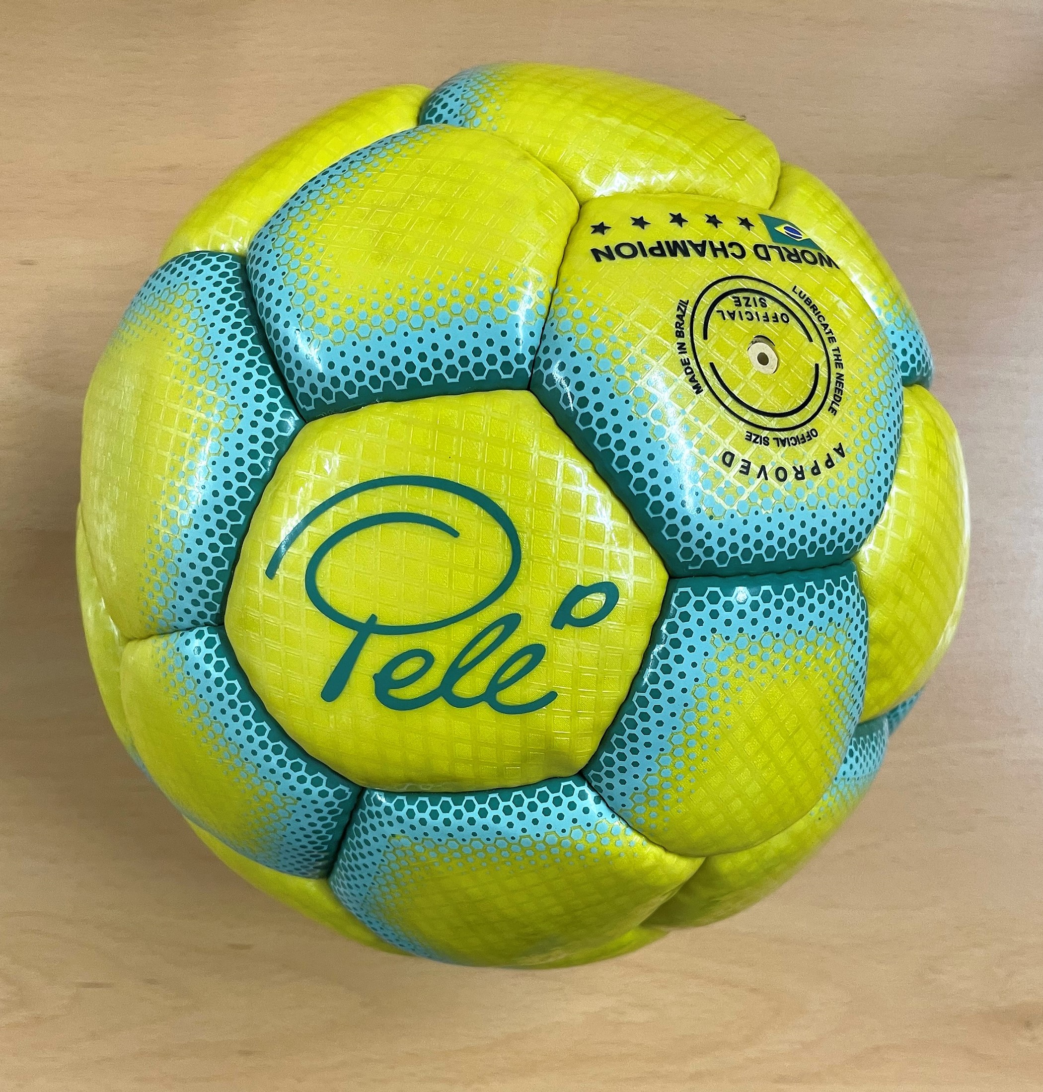 A yellow and green Café Pelé football owned by Pelé. The ball features Pelés faux signature in