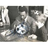 Football legend Pele signed nice vintage 8 x 6 inch black and white photo, signing a football for