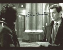 Show Jumper And Actor Oliver Skeete 10x8 Signed black and white Photo Pictured With Piers Brosnan