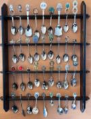 Collection of 34 White metal Collectable Spoons on wooden Rack. Spoons include Australia