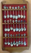 Collection of 24 White metal, Enamel Collectable Spoons from around the world, set on wooden rack