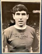 Tony Dunne signed 16x12 black and white photo pictured during his playing days with Manchester
