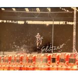 Evel Knievel signed 20x16 colour photo pictured during his iconic jump at Wembley Stadium in 1975.
