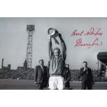 Football Autograph DENIS LAW 12 x 8 photo B W, depicting the Man United captain holding aloft the
