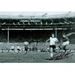 Football Legend, Geoff Hurst signed 12x8 black and white photograph pictured during an iconic moment