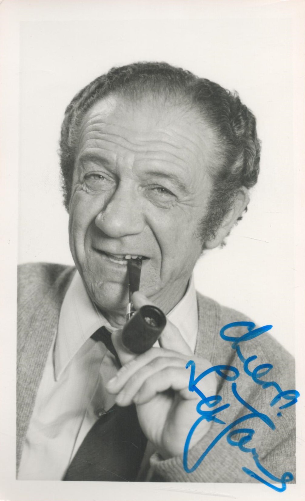 Sid James signed 6 x4 inch b/w photo smoking a pipe. Good condition. All autographs come with a