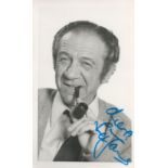 Sid James signed 6 x4 inch b/w photo smoking a pipe. Good condition. All autographs come with a