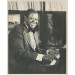 Music Oscar Peterson signed vintage 10 x 8 inch black and white photo. Sitting playing his piano.