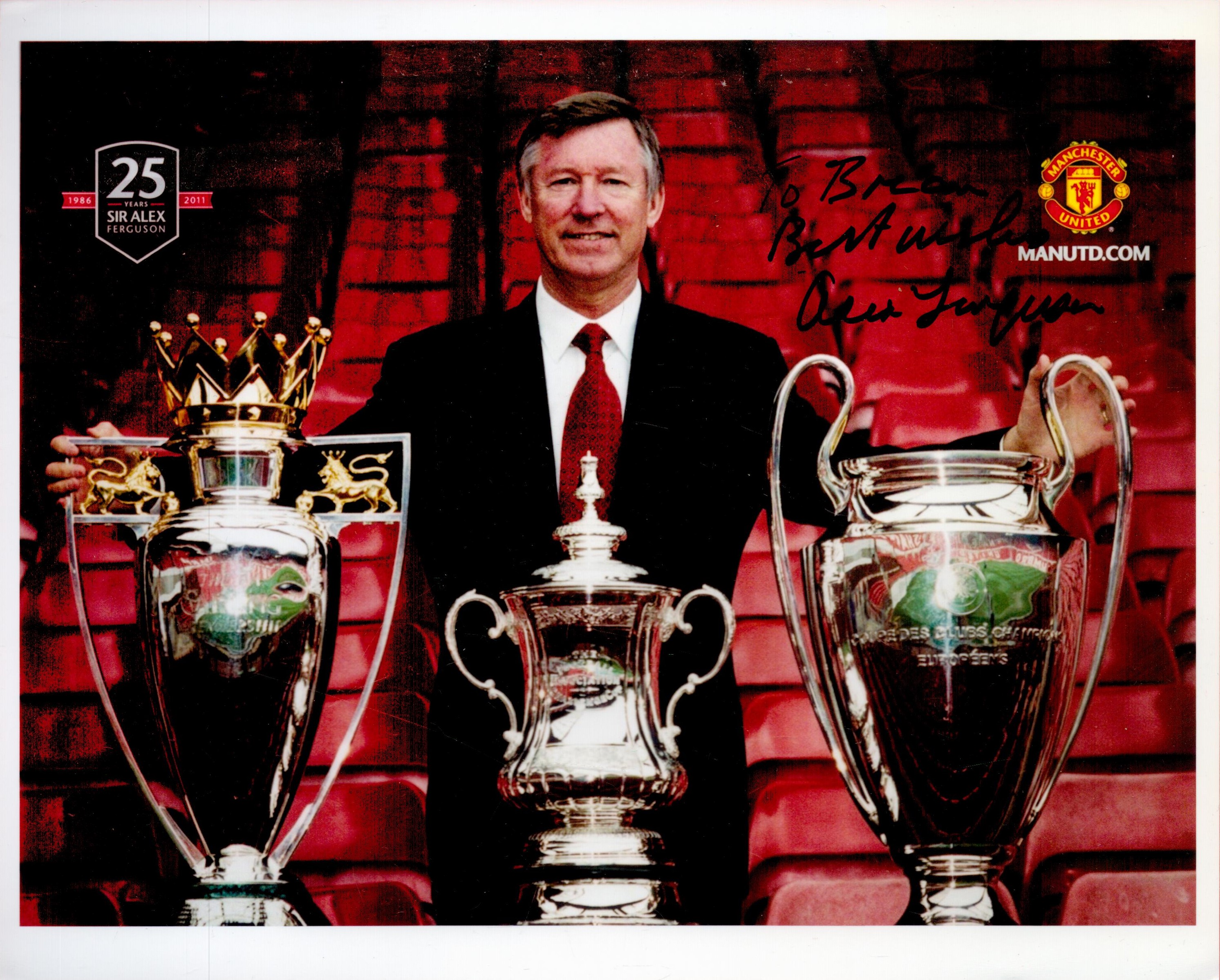 Football Alex Ferguson signed 10 x 8 inch colour photo standing with three trophies, to Brian.