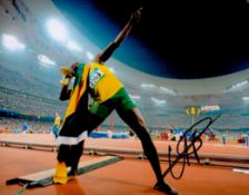 Olympic Champion Usain Bolt Signed 14 x 11 inch Colour Photo. Signed in Black ink. Good Condition.