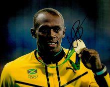 Usain Bolt signed 10 x 8 inch colour photo holding up his gold medal. Good Condition. All autographs