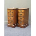 A pair of veneered bedside cabinets, each with four graduating drawers raised on plinth bases, 84.